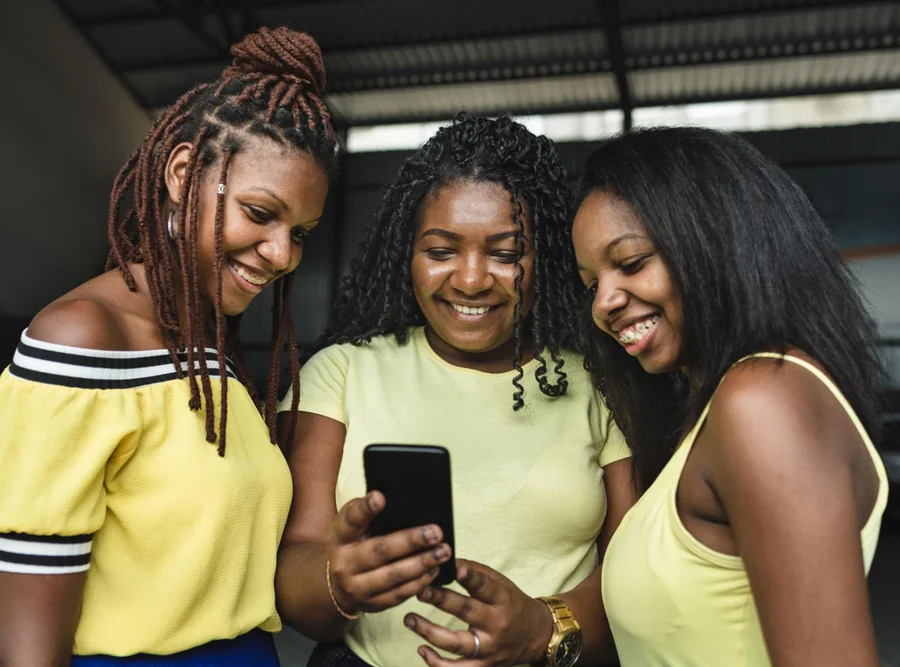 Três amigas juntas olhando o mesmo celular